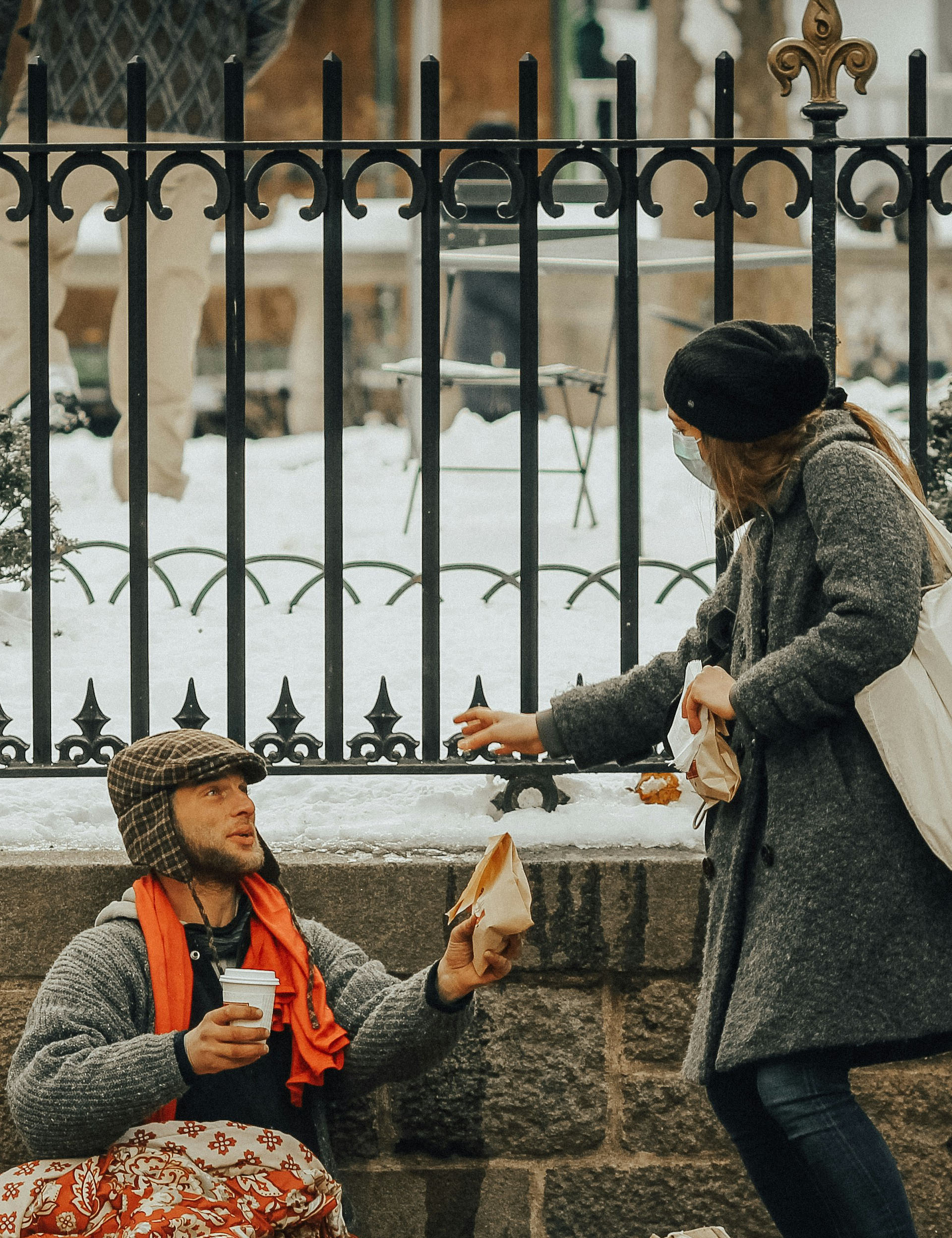 Woman reaching out to a homeless man, giving him food